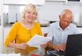 Portrait of a mature family couple looking at laptop at kitchen Royalty Free Stock Photo