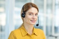 Portrait of mature female customer service worker, mature business woman with video call headset smiling and looking at Royalty Free Stock Photo
