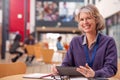 Portrait Of Mature Female Teacher Or Student With Digital Tablet Working At Table In College Hall Royalty Free Stock Photo