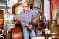 Portrait of mature man choosing vintage goods at antiques shop Royalty Free Stock Photo