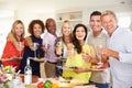 Portrait Of Mature Friends Enjoying Dinner Party At Home