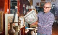 Portrait of mature man choosing vintage goods at antiques shop Royalty Free Stock Photo