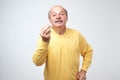 Portrait of mature handsome man in yellow shirt showing italian gesture that means what do you want