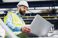 A portrait of an industrial man engineer with laptop in a factory, working.