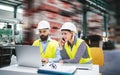 A portrait of an industrial man and woman engineer with laptop in a factory, working. Royalty Free Stock Photo