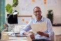 Portrait Of Mature Male Architect Working In Office At Desk Studying Plans For New Building Royalty Free Stock Photo