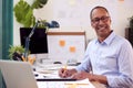 Portrait Of Mature Male Architect Working In Office At Desk Studying Plans For New Building Royalty Free Stock Photo