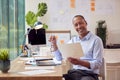 Portrait Of Mature Male Architect Working In Office At Desk Studying Plans For New Building Royalty Free Stock Photo