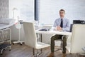 Portrait Of Mature Male Doctor Sitting Behind Desk In Office Royalty Free Stock Photo