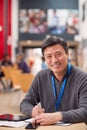 Portrait Of Mature Male Teacher Or Student With Digital Tablet Working At Table In College Hall Royalty Free Stock Photo