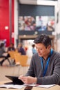 Portrait Of Mature Male Teacher Or Student With Digital Tablet Working At Table In College Hall Royalty Free Stock Photo