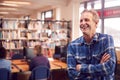 Portrait Of Mature Male Teacher Or Student In Library With Other Students Studying In Background Royalty Free Stock Photo