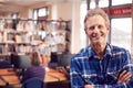 Portrait Of Mature Male Teacher Or Student In Library With Other Students Studying In Background Royalty Free Stock Photo