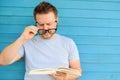 Portrait of mature man with big black eye glasses trying to read book but having difficulties seeing text because of vision