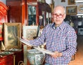 Portrait of mature man choosing vintage goods at antiques shop Royalty Free Stock Photo