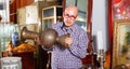 Portrait of mature man choosing vintage goods at antiques shop Royalty Free Stock Photo