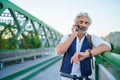 Portrait of mature man with electric scooter outdoors in city, using smartphone. Royalty Free Stock Photo