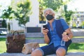 Portrait of mature man with face mask sitting outdoors in city, coronavirus concept. Royalty Free Stock Photo