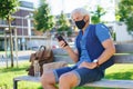 Portrait of mature man with face mask sitting outdoors in city, coronavirus concept. Royalty Free Stock Photo