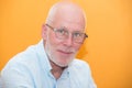 Portrait of a mature man with glasses, orange background