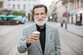 Portrait of mature man holding cup of coffee outdoors Royalty Free Stock Photo