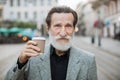 Portrait of mature man holding cup of coffee outdoors Royalty Free Stock Photo