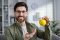 Portrait of a mature man at home, holding an apple in his hand, smiling and looking at the camera, close-up Royalty Free Stock Photo