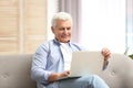 Portrait of mature man with laptop on sofa Royalty Free Stock Photo