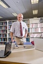 Portrait Of Mature Man At Library With Textbooks