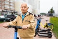 Portrait of mature man posing with electric scooter outdoor Royalty Free Stock Photo