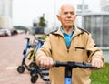 Portrait of mature man posing with electric scooter outdoor Royalty Free Stock Photo