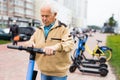 Portrait of mature man posing with electric scooter outdoor Royalty Free Stock Photo