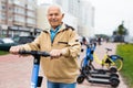 Portrait of mature man posing with electric scooter outdoor Royalty Free Stock Photo