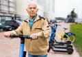 Portrait of mature man posing with electric scooter outdoor Royalty Free Stock Photo