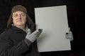 Portrait of a mature man protesting with a plain grey board on a black background