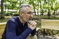 Portrait of a mature man sitting on a bench in an urban park Royalty Free Stock Photo