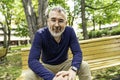 Portrait of a mature man sitting on a bench in an urban park Royalty Free Stock Photo