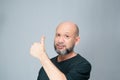 Portrait of mature man standing on white background. Bald bearded man making gestures