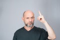 Portrait of mature man standing on white background. Bald bearded man making gestures