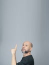 Portrait of mature man standing on white background. Bald bearded man making gestures