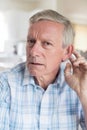 Portrait Of Mature Man Suffering From Deafness At Home