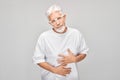 Portrait of mature man suffering from stomach pain isolated on white studio background. Intestinal and stomach Royalty Free Stock Photo