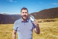 Portrait of mature man taking off protective face mask and breathing fresh air on top of the mountains