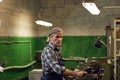 Mature manual worker working on lathe