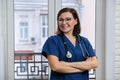 Portrait of mature nurse woman in blue uniform with stethoscope Royalty Free Stock Photo