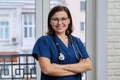 Portrait of mature nurse woman in blue uniform with stethoscope Royalty Free Stock Photo