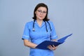 Portrait of mature nurse woman holding clipboard Royalty Free Stock Photo