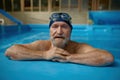 Portrait of mature senior man wearing swimming hat and goggles at pool Royalty Free Stock Photo