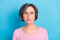 Portrait of mature serious intelligent businesswoman in glasses wear pink pullover isolated on blue color background