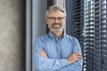 Portrait of mature successful businessman boss, senior gray-haired man inside office smiling looking at camera with Royalty Free Stock Photo